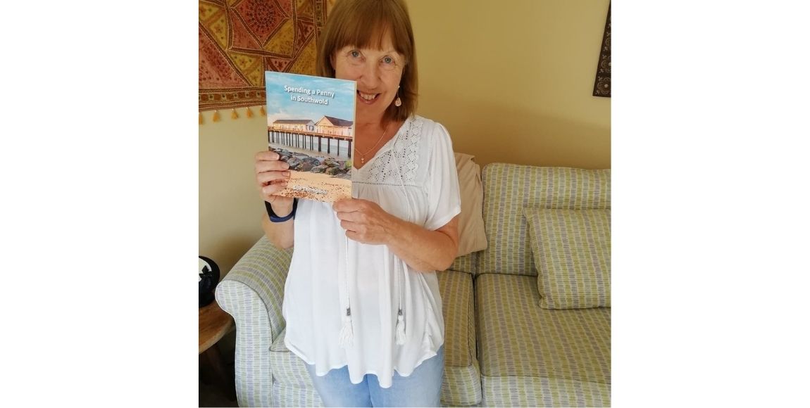 Sue Thompson holding her book Spending a penny in Southwold